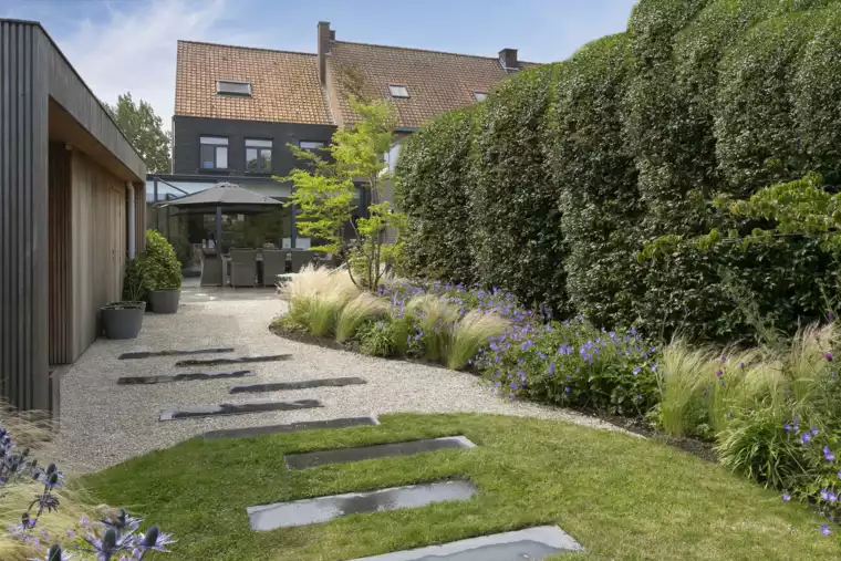Speelse kusttuin met Dutchborder vol bloemenpracht en tuinberegening te Oostduinkerke (16) -  - Tuinaanleg